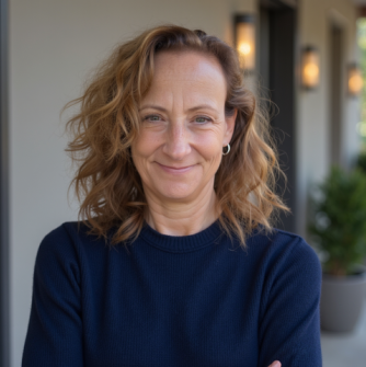 Woman in a blue crewneck standing in a hallway