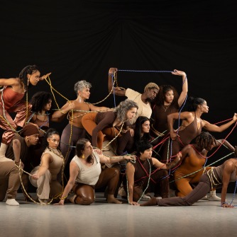 Large group of dancers facing to the right on a stage