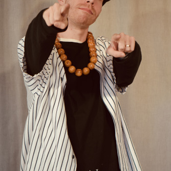 Man wearing baseball cap and baseball shirt pointing forward