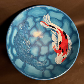 A blue bowl with an orange fish on it