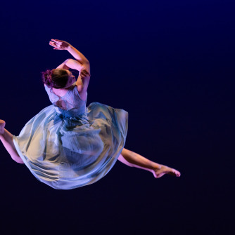 Dancer in blue spinning through the air