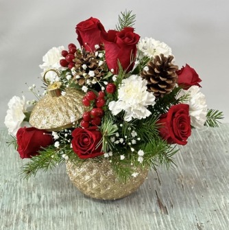 Red and white floral arrangement with pinecones and gold vase