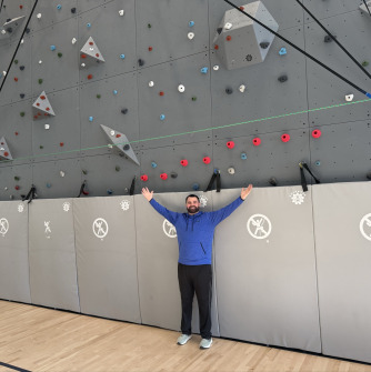 Jeffrey Stephens ’15, ’19G in front of an indoor rockwall climbing gym