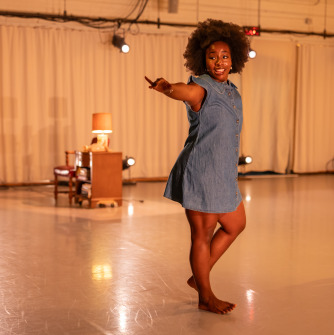 Person wearing a gray dance posed in the middle of a dance studio
