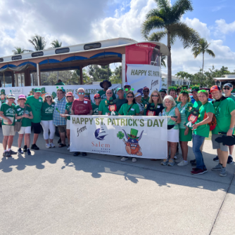 2025 attendees at the Naples, Florida St. Patrick's Day Parade in front of a decorated trolley