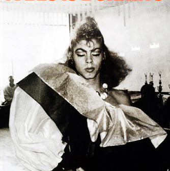 An black and white photo of a person dressed in drag, with the caption "Paris is Burning" above them.
