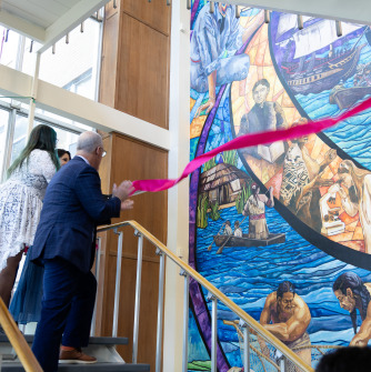 University officials and community members celebrate a ribbon cutting of the new Meier Hall mural