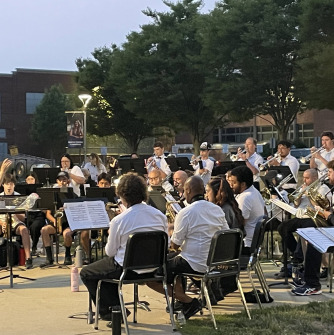 Band playing outside in the evening with conductor