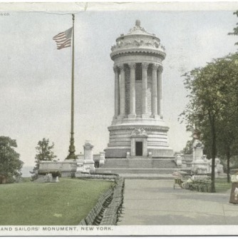 Marble monument on a green lawn next to a flag
