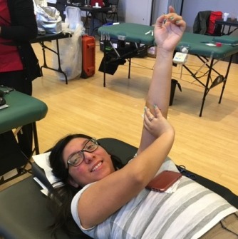 Student lying on a table donating blood