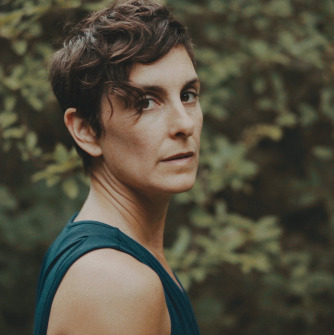 Woman looking over shoulder in a blue tank top
