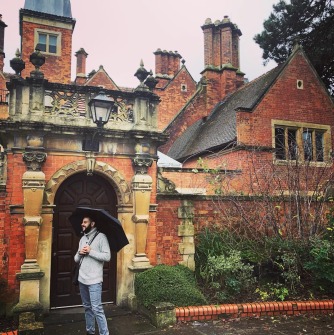 Phot of Damian Barrous-Dume with an umbrella outside of Burials House at City, London University