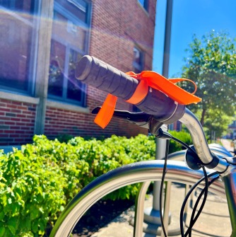Bike with an orange ribbon tied to the handlebar.