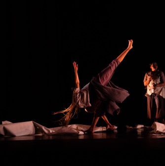 Two dancers with paper on the floor at their feet