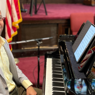 Javier Marquez sits at a piano