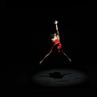 Dancer dressed in red leaping in the air