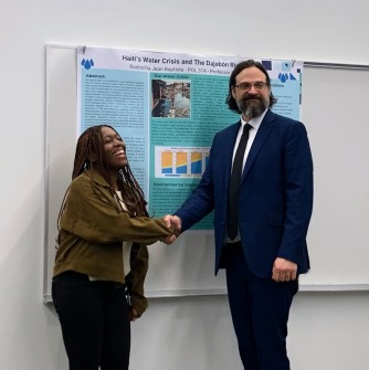 Rodnicha Jean Baptiste is congratulated by Professor Guy Bellino, Earth Days Planning Co-Chair, on winning third place in the Research Poster Competition