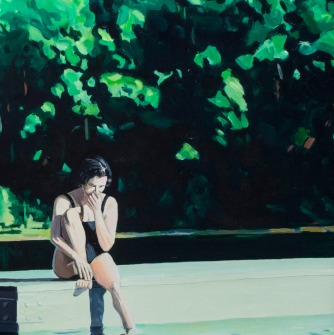 Woman sitting on a dock in front of trees