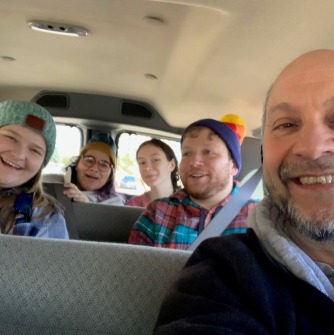 Professor Steven Silvern and geography and sustainability students in van on tour of Rockies