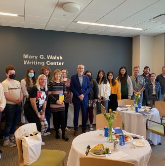 Group photo of DeCiccio standing with tutors and students in the writing center