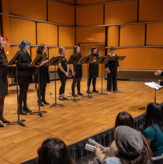 People singing on the Recital Hall stage.