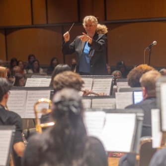 woman wearing blue jacket and shirt conducting
