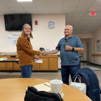 Samantha is receving her award letter from Mr. Tom Rich