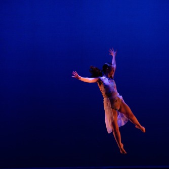 Woman dressed in white jumping in the air