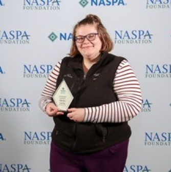 Elaina Curtis, SSU HESA Gradate 2023, holding her Jim Rhatigan Fellowship Award at the NASAP National Conference