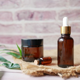 Three brown bottles on beige towel used for aroma therapy
