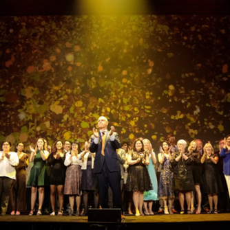 President Keenan leads the celebration with a group of students on stage at the 2023 Campaign launch