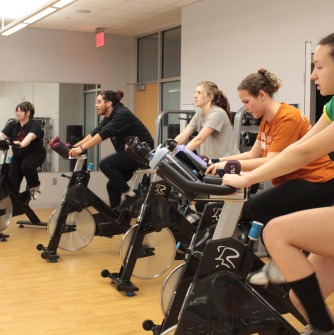 Group of people riding Spin bikes.