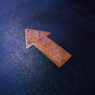Orange arrow on a blue pavement