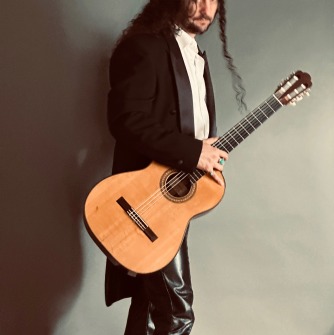 Aaron Larget-Caplan standing with guitar