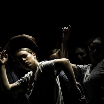 Dancers moving in a group with sweeping arm gestures