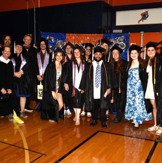 Student and faculty pose in the gym before the ceremony