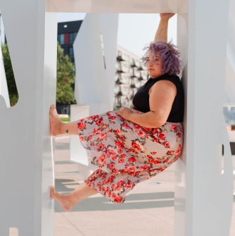 Angelina Benitez in a window frame wearing floral skirt and black top