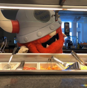 Superfan reaching for food in the dining hall