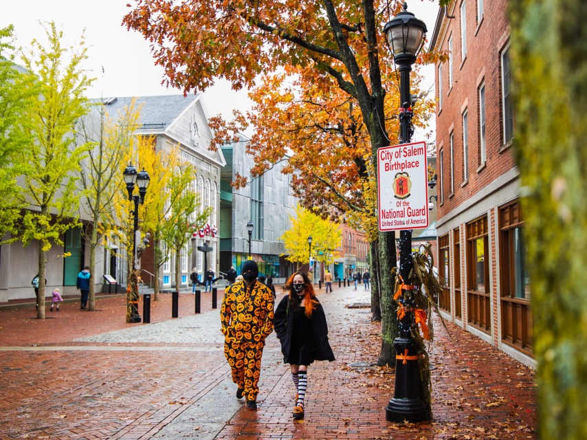 People in costumes walk the street of Salem