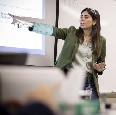 Laura Laranjo in front of a white board while teaching her biology class