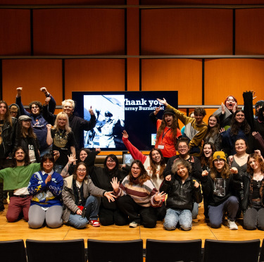 Music and dance students standing on stage, posing for a thank you picture for the Burnstine Trust