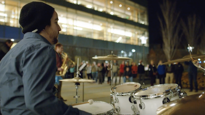 A student musician plays drums on the quad