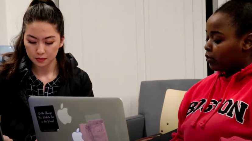 Two young women sitting in front of a laptop