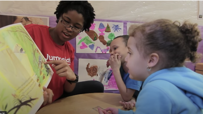 A Jumpstart volunteer reads to two children