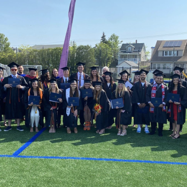 Sport and Movement Science graduates pose for a photo on Alumni Field.